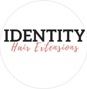 Identity Hair Extensions logo featuring bold black uppercase text paired with elegant coral‑pink cursive lettering on a white background.