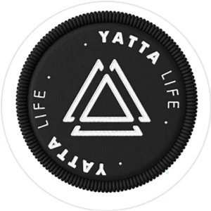 Yatta Life logo featuring a circular black patch with a white double‑triangle symbol in the center and the words “YATTA LIFE” around the edge, symbolizing adventure and active living.